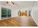 Open floor plan view of living room with wood floors, a sliding glass door, and connected kitchen at 703 Sailfish Rd, Winter Springs, FL 32708