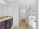 Well-lit bathroom with a walk-in shower, spacious countertop, and tile flooring at 734 Andalusia Loop, Davenport, FL 33837