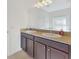 Bright bathroom featuring a dual sink vanity with granite countertop and modern lighting at 734 Andalusia Loop, Davenport, FL 33837