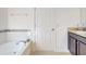 Bathroom featuring a soaking tub, decorative tile accents, and a granite vanity at 734 Andalusia Loop, Davenport, FL 33837