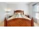 Bright bedroom boasting a wooden bed frame, two end tables, and neutral-toned walls at 734 Andalusia Loop, Davenport, FL 33837