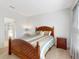 Comfortable bedroom featuring neutral carpet, a wooden bed frame, and an ensuite bathroom at 734 Andalusia Loop, Davenport, FL 33837