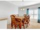 Dining area featuring a wooden table, six chairs, and natural light, with view to the kitchen at 734 Andalusia Loop, Davenport, FL 33837