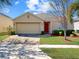 Charming single-story home with a brick driveway, well-maintained lawn, and a red front door at 734 Andalusia Loop, Davenport, FL 33837