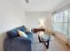 Cozy living room featuring a comfortable blue sofa and a large window with floral curtains at 734 Andalusia Loop, Davenport, FL 33837