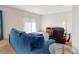 Spacious living room with plush blue sofa, sliding glass doors, and a cozy seating area at 734 Andalusia Loop, Davenport, FL 33837