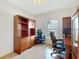 Home office space with wood desk, bookshelves, and two rolling office chairs at 734 Andalusia Loop, Davenport, FL 33837