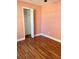 Cozy bedroom with wood floors, a closet and a light peach colored wall at 7520 Marietta St, Orlando, FL 32807