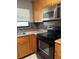 Well-equipped kitchen with wooden cabinets, black appliances, and natural light from the window at 7520 Marietta St, Orlando, FL 32807