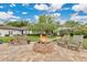 Backyard with a brick fire pit, multiple chairs, a large tree for shade, and a partial view of the back of the home at 8244 Oakland Pl, Orlando, FL 32819