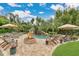 Luxurious backyard with fire pit and lush lounge area overlooks a resort style pool area at 8244 Oakland Pl, Orlando, FL 32819