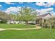 Inviting backyard with a well-manicured lawn, mature tree, and a charming walkway to the house at 8244 Oakland Pl, Orlando, FL 32819