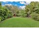 Lush backyard featuring a well-maintained lawn and a charming wooden shed at 8244 Oakland Pl, Orlando, FL 32819