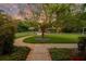 Serene backyard landscape showcasing a winding pathway, mature trees with string lights, and a relaxing outdoor seating area at 8244 Oakland Pl, Orlando, FL 32819