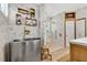 Modern bathroom featuring a stainless steel soaking tub, walk-in shower and floating wood shelves at 8244 Oakland Pl, Orlando, FL 32819