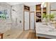 Bright bathroom featuring a modern single sink vanity, walk-in shower with neutral tiling and built in wood shelves at 8244 Oakland Pl, Orlando, FL 32819