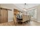 Dining room features a table with seating for eight, a decorative light fixture, and hardwood floors at 8244 Oakland Pl, Orlando, FL 32819