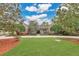 Beautifully landscaped front yard with a well-manicured lawn and mature trees leading to a stately brick home at 8244 Oakland Pl, Orlando, FL 32819
