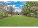 Wide front yard with expansive lawn, mature trees and meticulous landscaping create a serene setting at 8244 Oakland Pl, Orlando, FL 32819