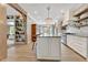 Bright kitchen featuring a large island with barstool seating, open shelving, and modern countertops at 8244 Oakland Pl, Orlando, FL 32819