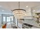 Bright kitchen with crystal chandelier lighting, white cabinetry, and a stainless steel gas range at 8244 Oakland Pl, Orlando, FL 32819