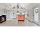 Well-lit kitchen with white cabinets, an island, clerestory windows, and a cozy fireplace at 8244 Oakland Pl, Orlando, FL 32819