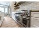 Gourmet kitchen featuring a stainless steel oven range, custom cabinetry, and open shelving at 8244 Oakland Pl, Orlando, FL 32819