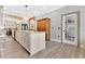 Spacious kitchen featuring custom cabinets, a large center island, pendant lighting, and textured tile accent wall at 8244 Oakland Pl, Orlando, FL 32819