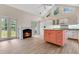 Bright kitchen with a fireplace, white cabinets, and a coral-colored central island at 8244 Oakland Pl, Orlando, FL 32819