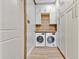Efficient laundry room with modern washer and dryer units and built-in storage cabinets at 8244 Oakland Pl, Orlando, FL 32819