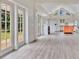 Bright living room featuring beautiful hardwood floors, french doors, and an open kitchen layout at 8244 Oakland Pl, Orlando, FL 32819