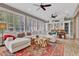 Bright living room showcasing a sectional sofa, brick flooring, large windows, and a ceiling fan at 8244 Oakland Pl, Orlando, FL 32819