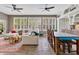 Inviting living room with a large sectional, brick flooring, ceiling fans, and tons of natural light at 8244 Oakland Pl, Orlando, FL 32819