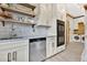 Functional pantry area with stainless steel appliances, custom cabinets, and open shelving, offering ample storage at 8244 Oakland Pl, Orlando, FL 32819