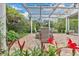 Covered patio with a glass roof, a dining table and chairs, and colorful flower beds at 8244 Oakland Pl, Orlando, FL 32819