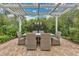 Open pergola-covered patio with brick flooring, a dining table, seating, and greenery all around at 8244 Oakland Pl, Orlando, FL 32819