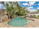 Backyard pool with grotto, rock waterfall, and tropical foliage creates private oasis at 8244 Oakland Pl, Orlando, FL 32819
