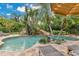 Beautiful freeform pool features mature tropical landscaping, slide and sunning deck at 8244 Oakland Pl, Orlando, FL 32819