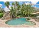 Lush tropical landscaping accents this beautiful swimming pool with grotto and waterfall at 8244 Oakland Pl, Orlando, FL 32819