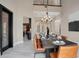 Bright dining room with a contemporary black dining table with leather chairs and a modern chandelier at 8336 Boyla Ct, Windermere, FL 34786