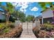 An ornate driveway gate with beautiful landscaping leading to a luxurious home, enhancing curb appeal and privacy at 8336 Boyla Ct, Windermere, FL 34786