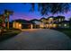 Elegant home featuring a spacious driveway, a grand exterior, and meticulously manicured landscaping, illuminated at twilight at 8336 Boyla Ct, Windermere, FL 34786