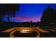 Backyard fire pit with bench seating offering a cozy space for outdoor gatherings, illuminated by soft landscape lighting at 8336 Boyla Ct, Windermere, FL 34786