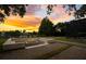 Outdoor fire pit area at dusk, surrounded by trees and manicured lawn at 8336 Boyla Ct, Windermere, FL 34786