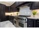 Modern kitchen featuring dark cabinetry, stainless-steel appliances, and a marble floor at 8336 Boyla Ct, Windermere, FL 34786