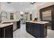 Bright kitchen featuring an island with stainless-steel appliances, dark cabinets, and marble floors at 8336 Boyla Ct, Windermere, FL 34786