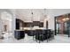 A modern open-concept kitchen featuring dark cabinetry, pendant lighting, and a marble floor at 8336 Boyla Ct, Windermere, FL 34786