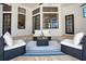 Elegant outdoor living area with comfortable seating, an outdoor fireplace, and large windows offering natural light at 8336 Boyla Ct, Windermere, FL 34786