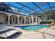 Luxury screened pool featuring a bar with a TV and lounge chairs at 8336 Boyla Ct, Windermere, FL 34786