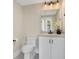 Stylish powder room with a modern vanity, granite countertop, decorative mirror, and a toilet with black fixtures at 8336 Boyla Ct, Windermere, FL 34786